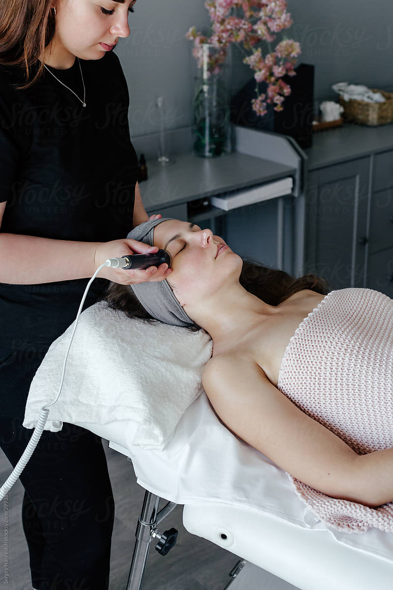 Female beautician doing ultrasonic massage to woman
