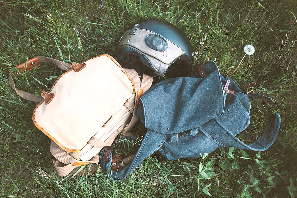 Bags and a motor helmet lying in the grass