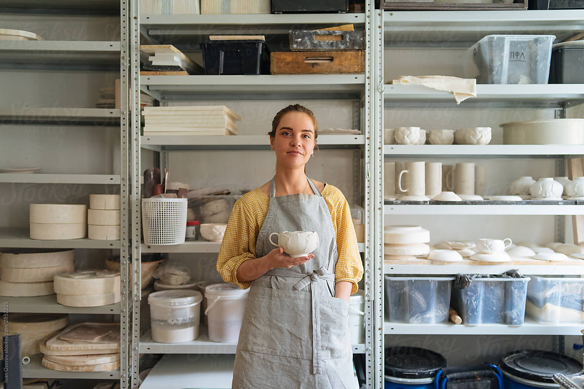 Woman master ceramist posing with a cup in her hands
