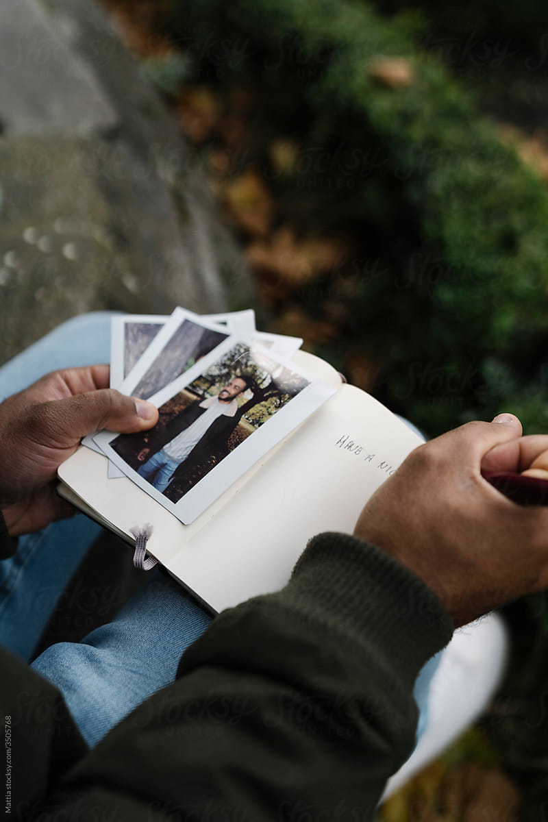 Man Archiving Instant Pictures into his Journal