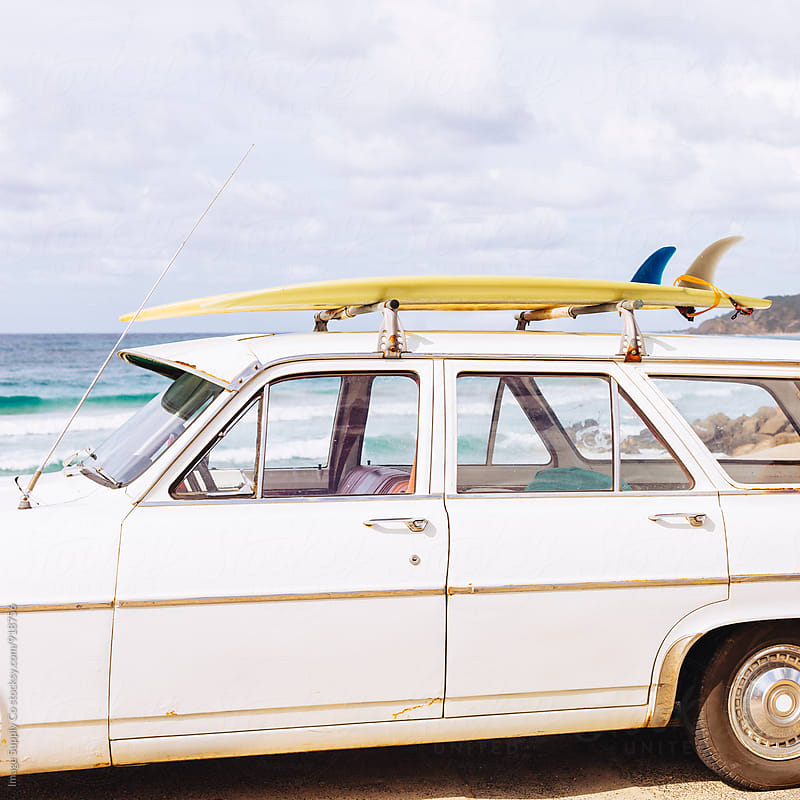 White vintage car at the beach with surf boards