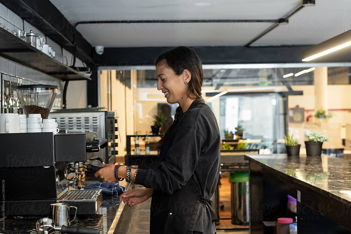 Female barista making coffee at espresso machine