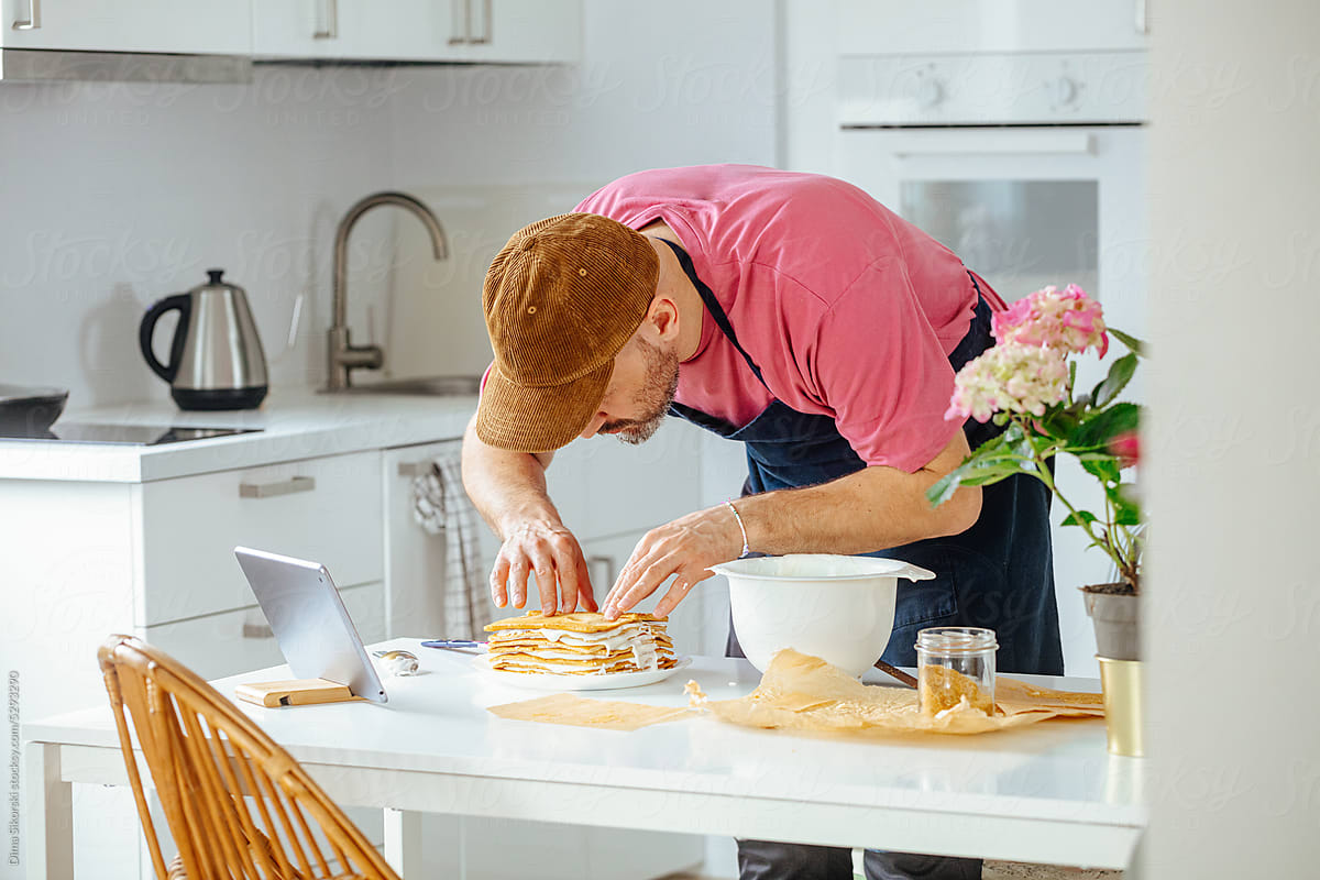 A man is enthusiastically engaged in cooking a cake