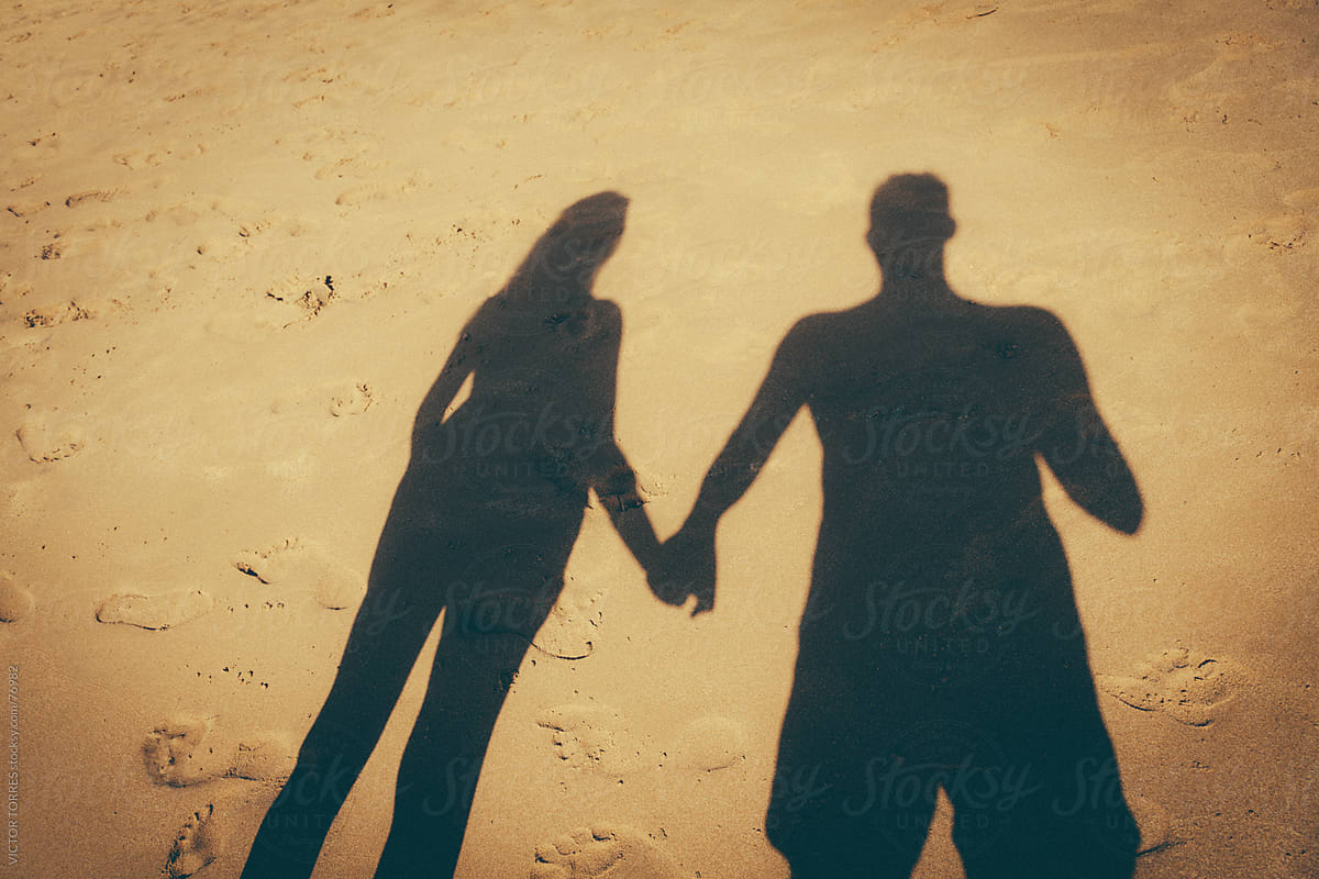 Couple Shadow Join Hands on the Beach Sand