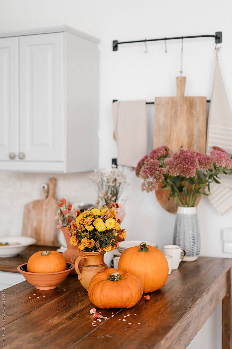 Pumpkins and flowers on kitchen table