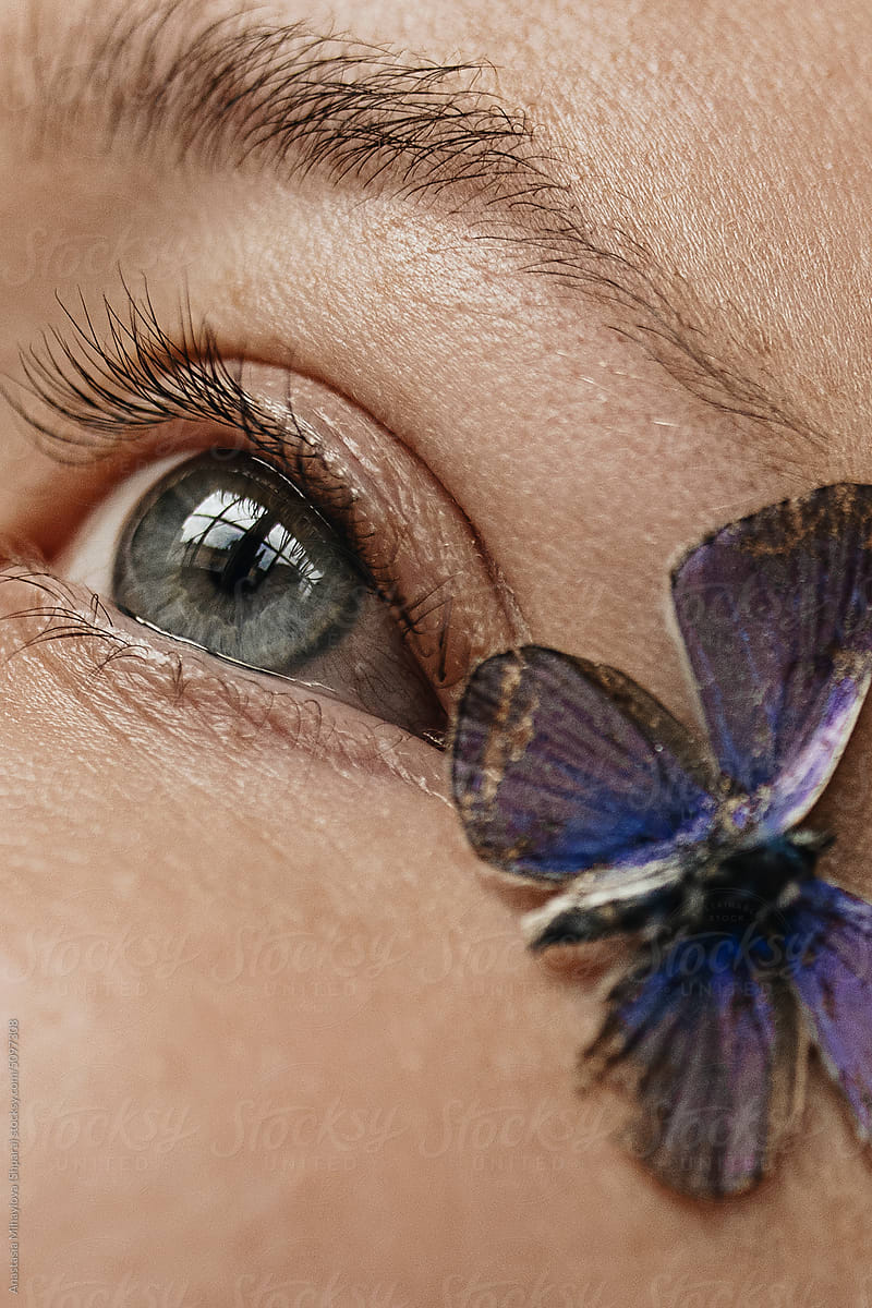 Close up woman\'s eye and butterfly on the face