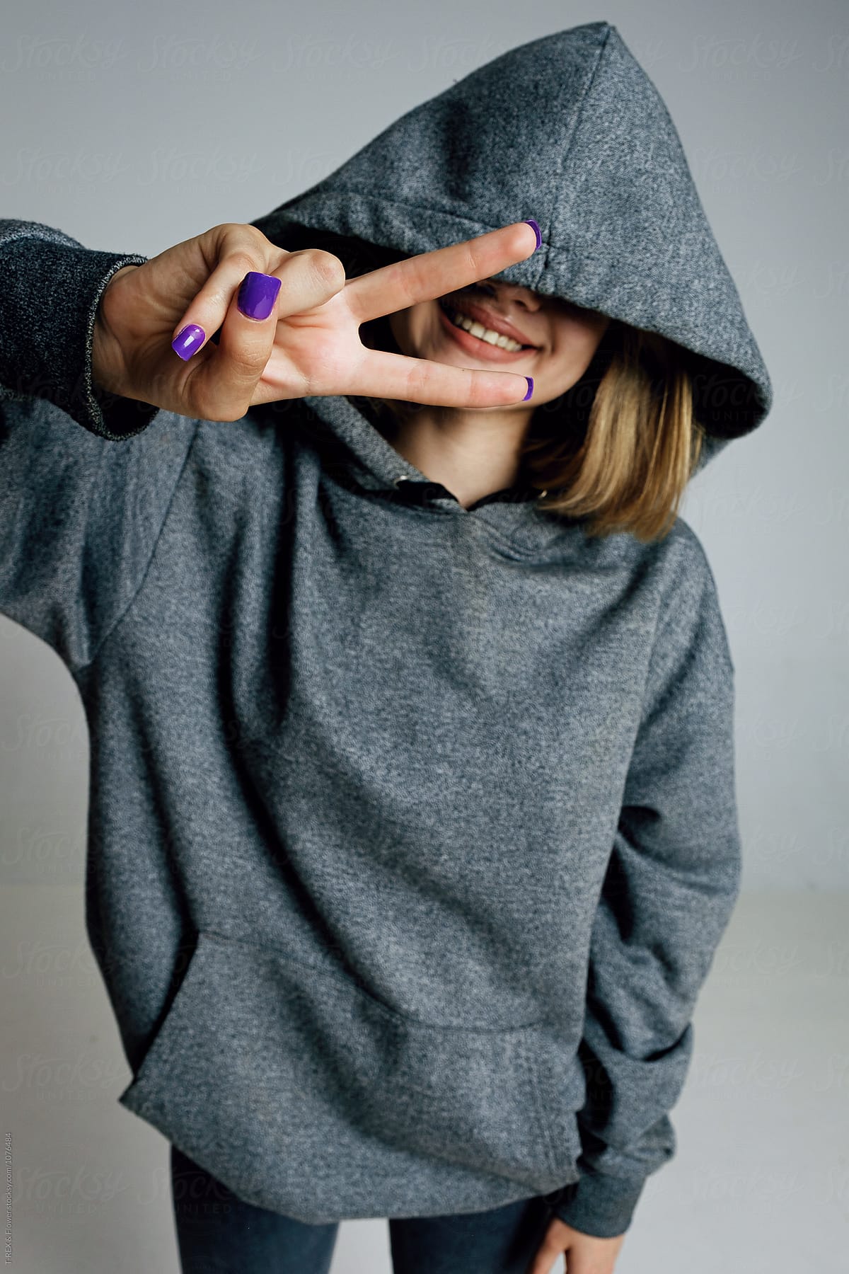 Smiling Girl Showing Peace Sign At Camera By Stocksy Contributor