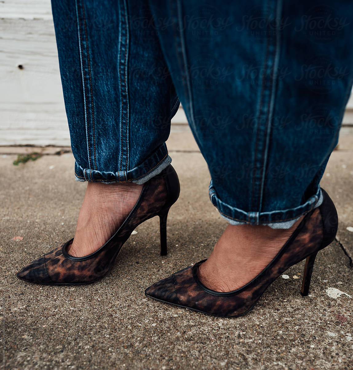Woman in blue jeans and black see through heel