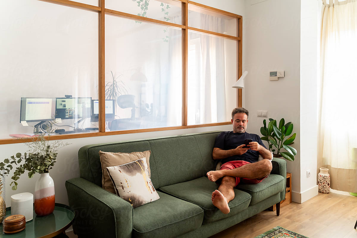 Man Using Mobile Phone At Living Room