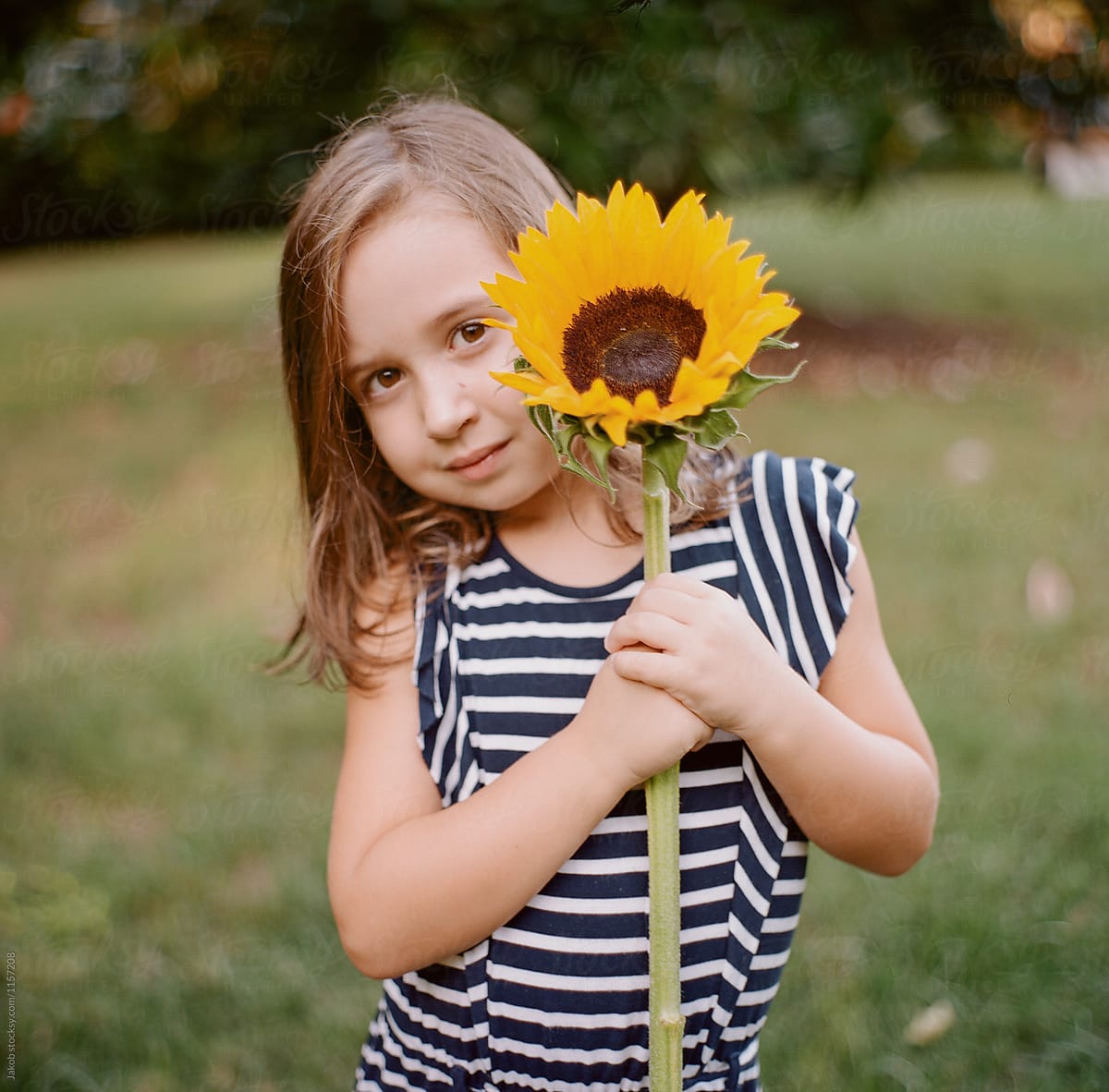 Cute Young Girl With A Big Sunflower By Stocksy Contributor Jakob 