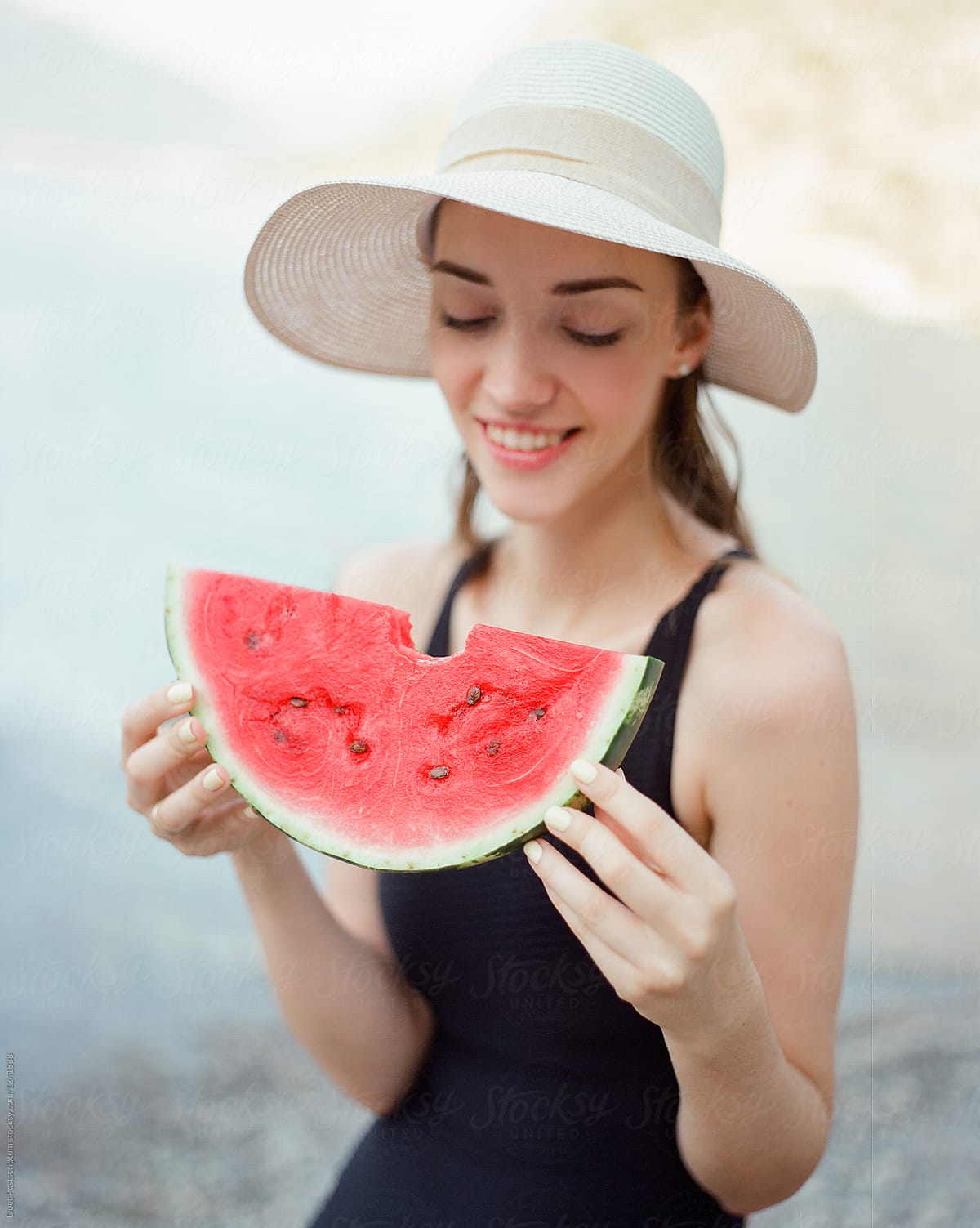 Smiling woman holding slice of watermelon