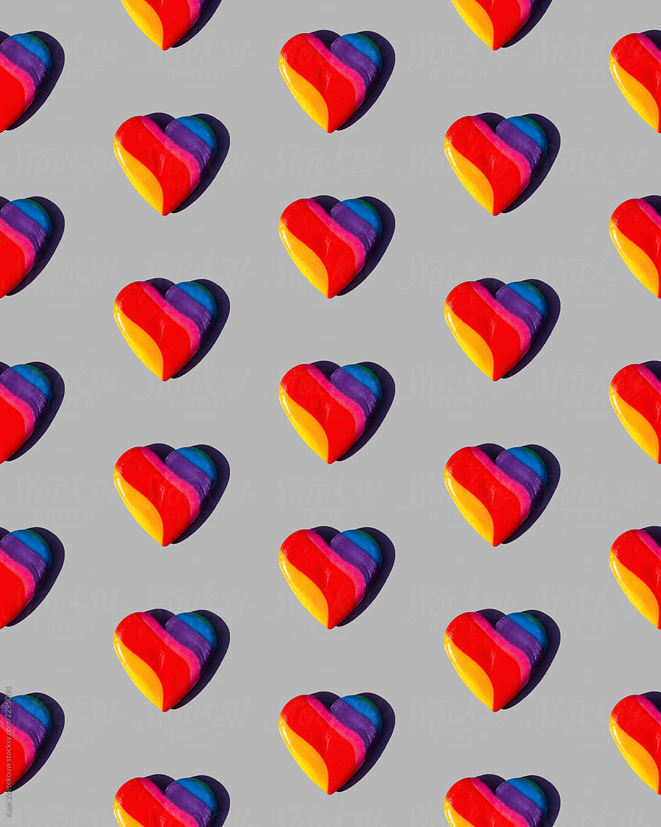 Rainbow-colored candy hearts patterned on grey
