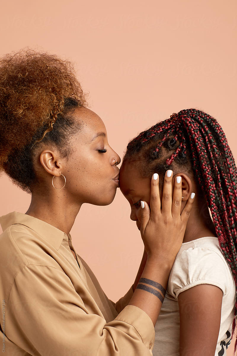 Young Woman Kissing Her Kid Sister