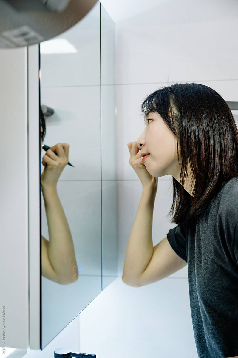 Woman applying makeup in the morning