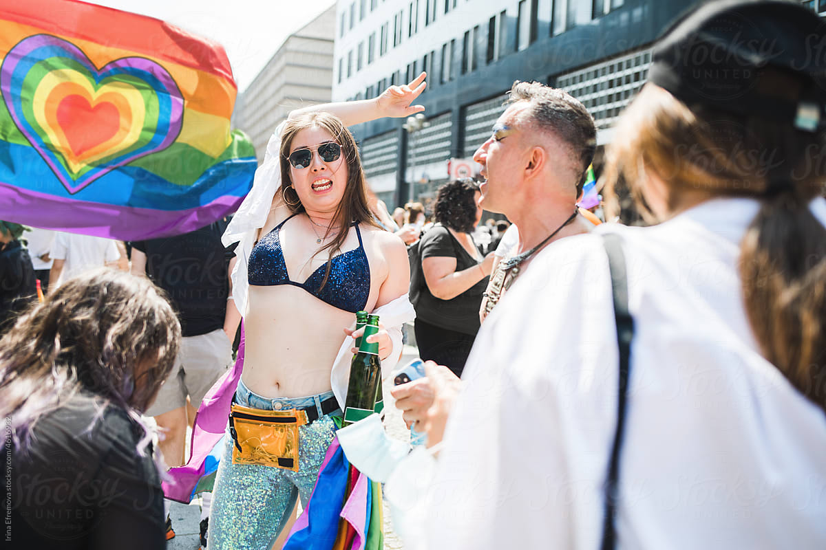 High energy girl dancing outside with friends during Pride