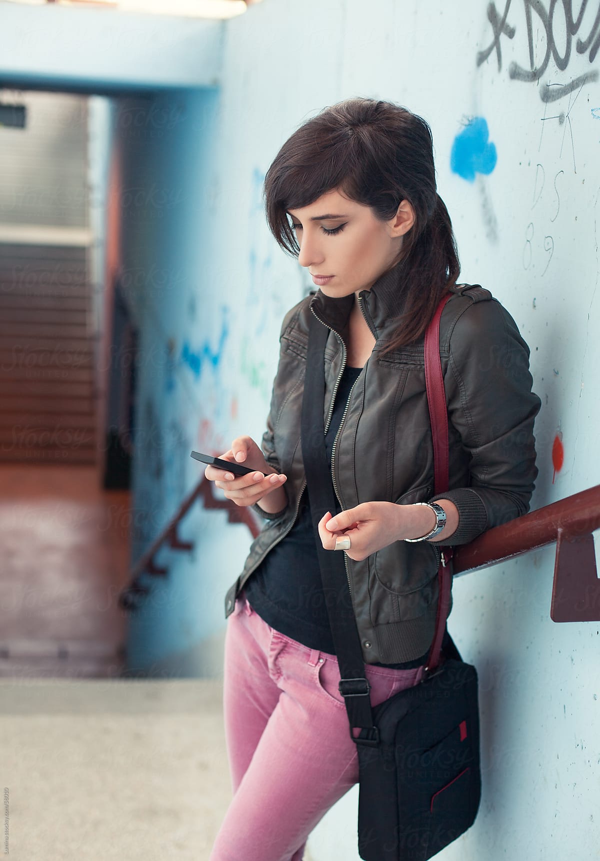Woman Texting By A Graffiti Wall By Stocksy Contributor Lumina Stocksy