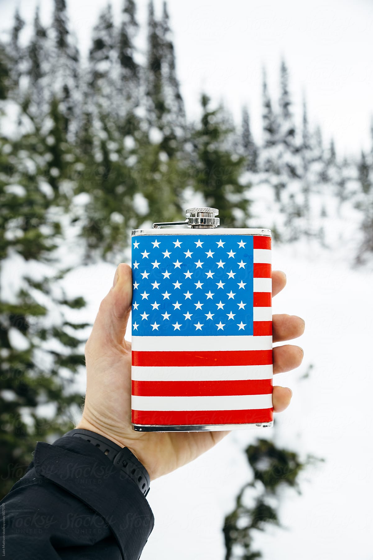 Man Holding Out American Flag Flask In Hand In Snowy Forest
