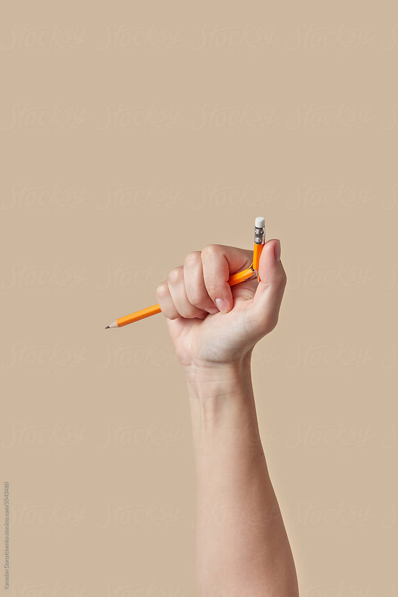Female hand breaking graphite pencil.