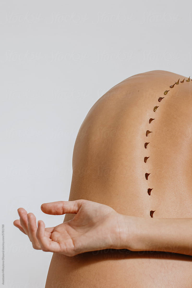 Close up photo of woman's skin of the back with thorns on spine