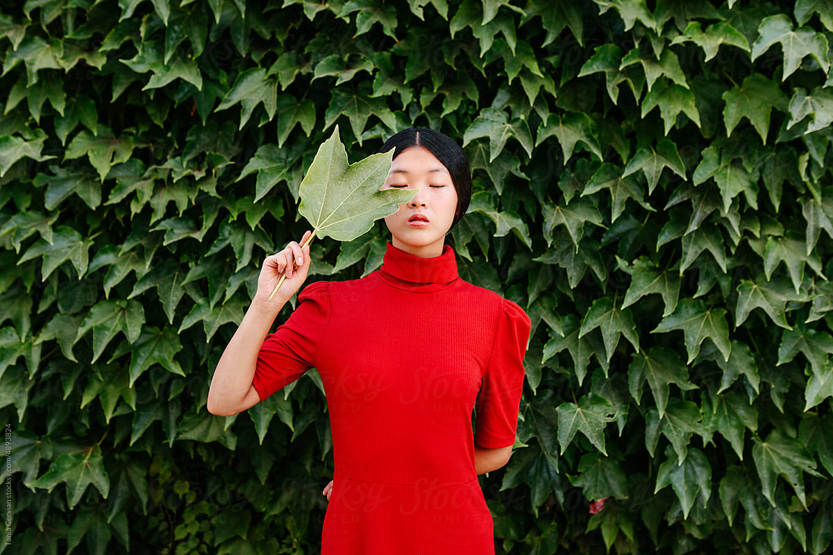 Calm woman with eyes closed holding leaf