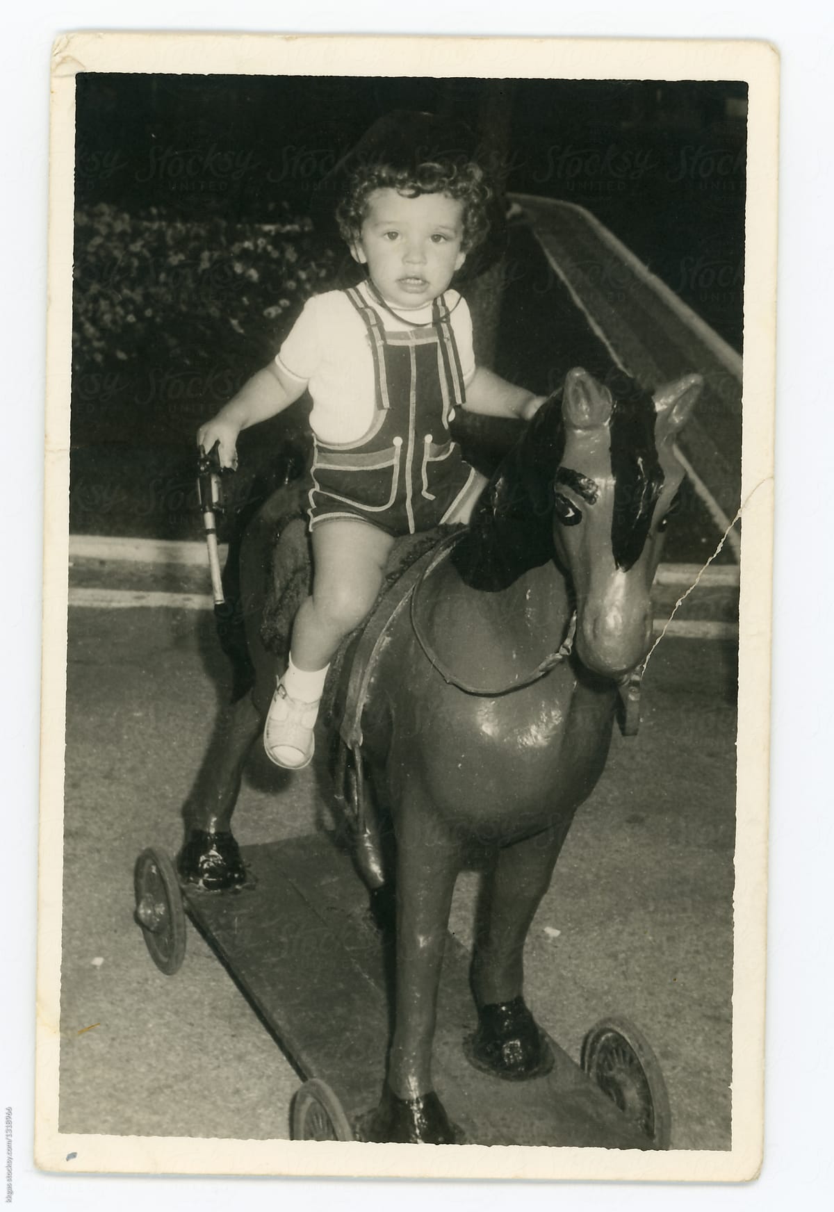 Black and white print of a little boy riding a horse toy