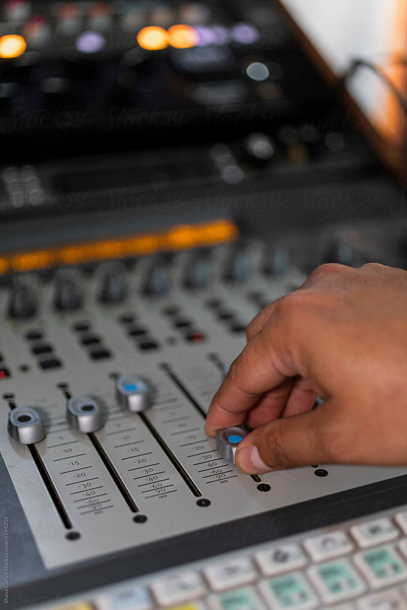 Male right hand moving buttons from an audio console