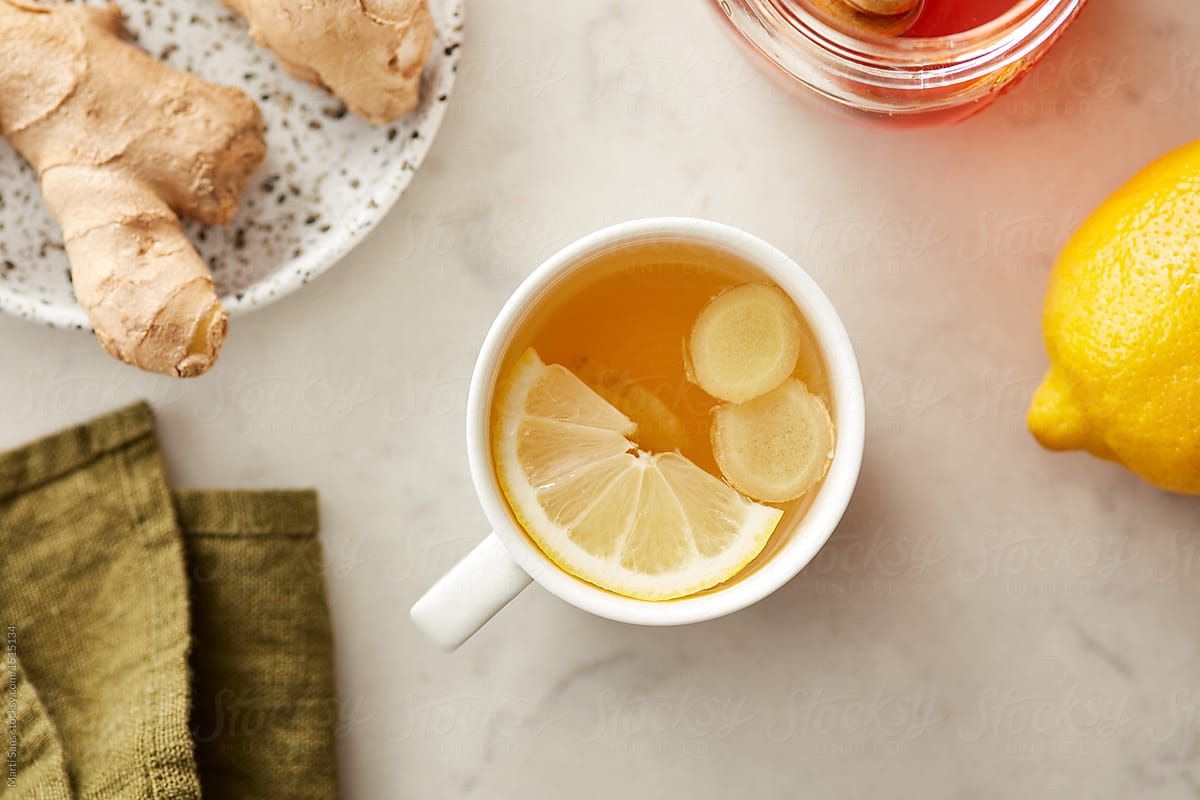 Top view of cup of lemon tea with honey and ginger.