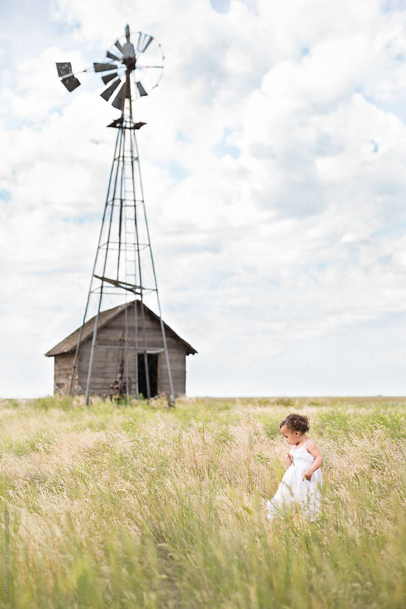 Toddler in field by windmill