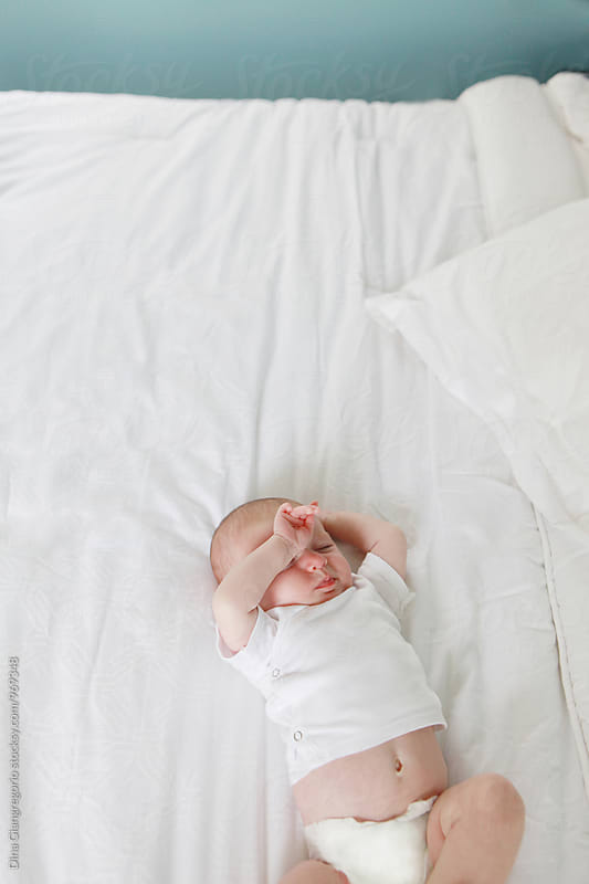 Newborn Baby On White Bed Sleeping