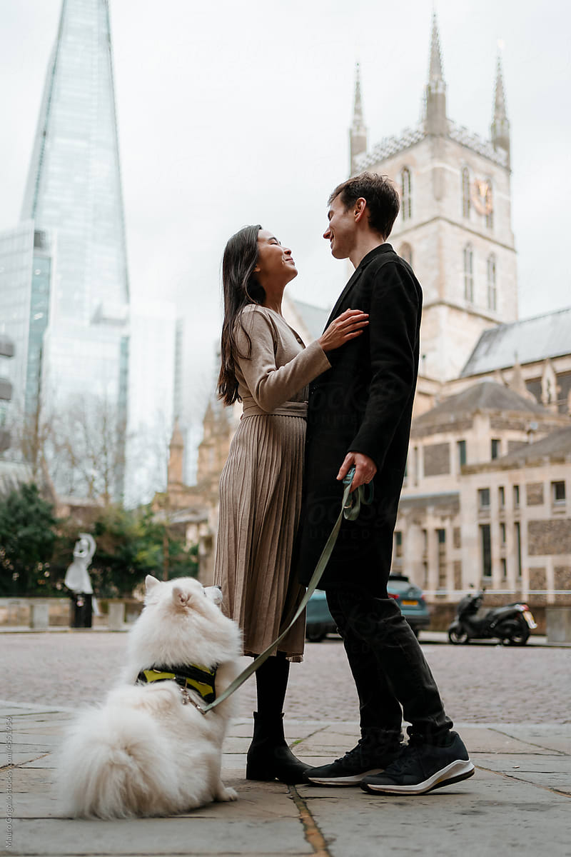Lovers with a dog are spending a romantic moment in the city