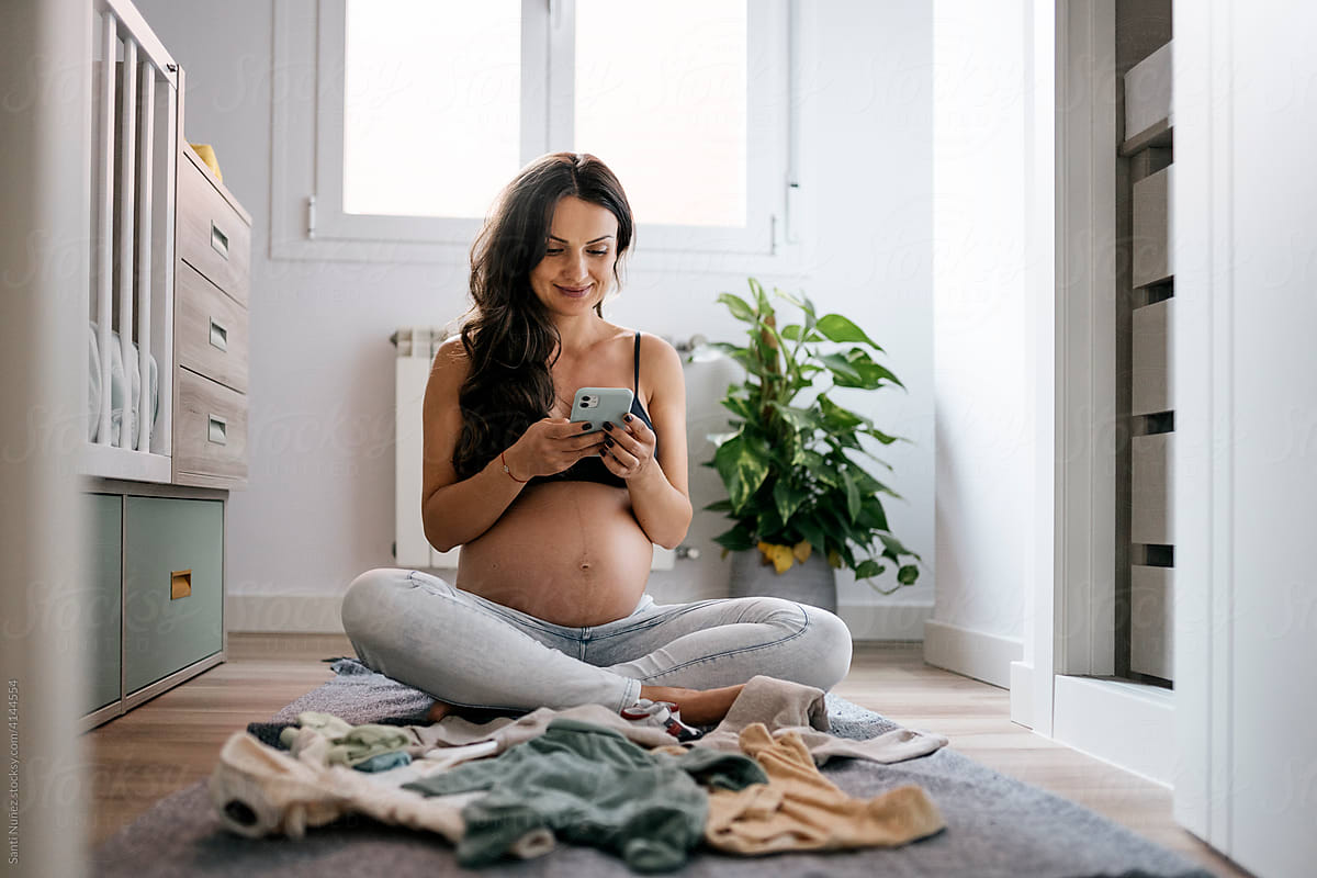 Portrait of pregnant woman using phone at home