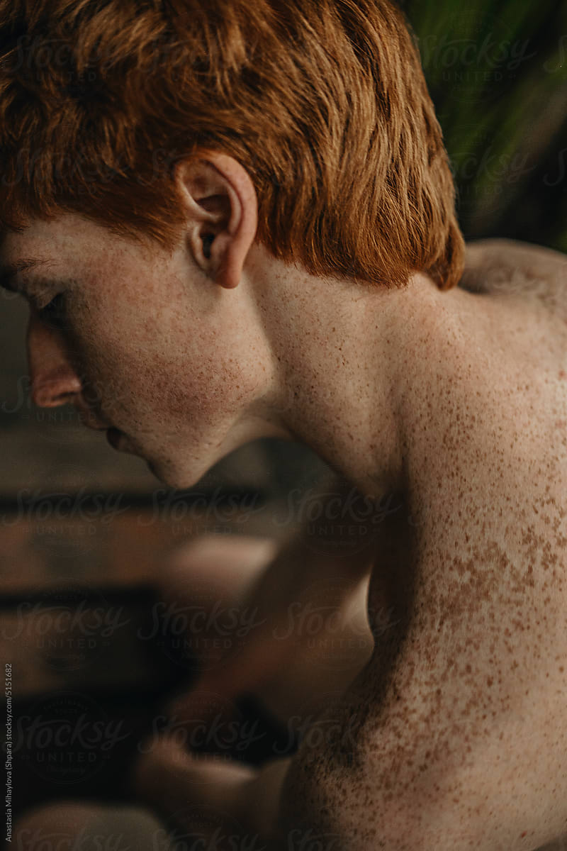 Half-Face Portrait and Shoulders of Freckled Ginger Man in the Jungle