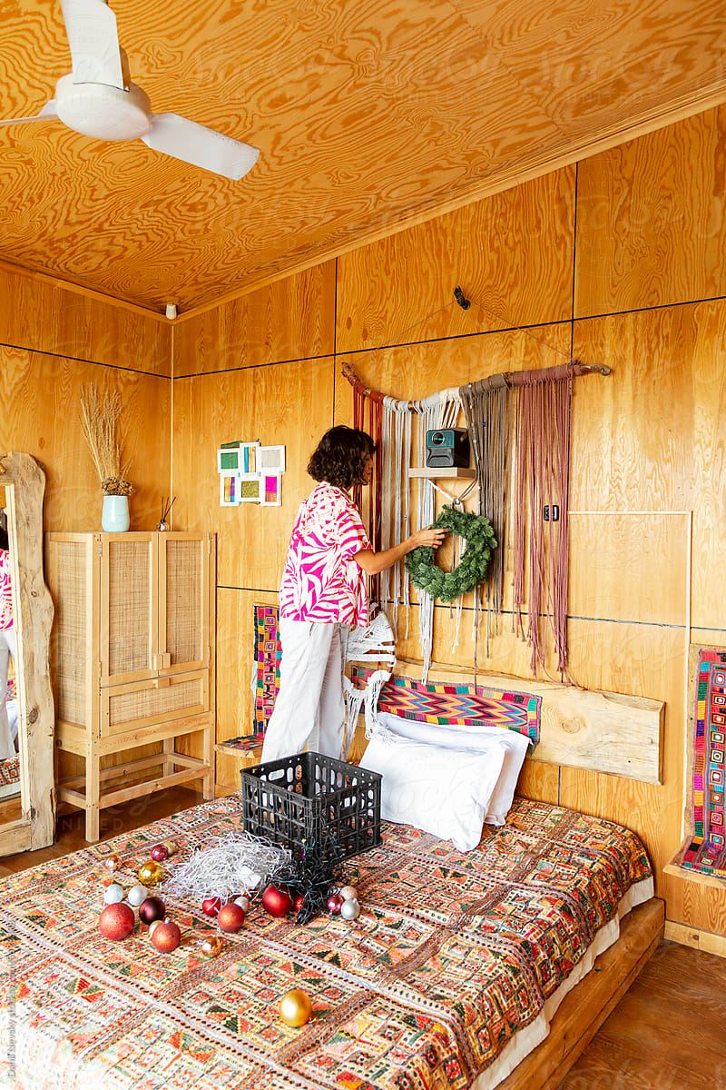Woman hanging seasonal decor in bedroom