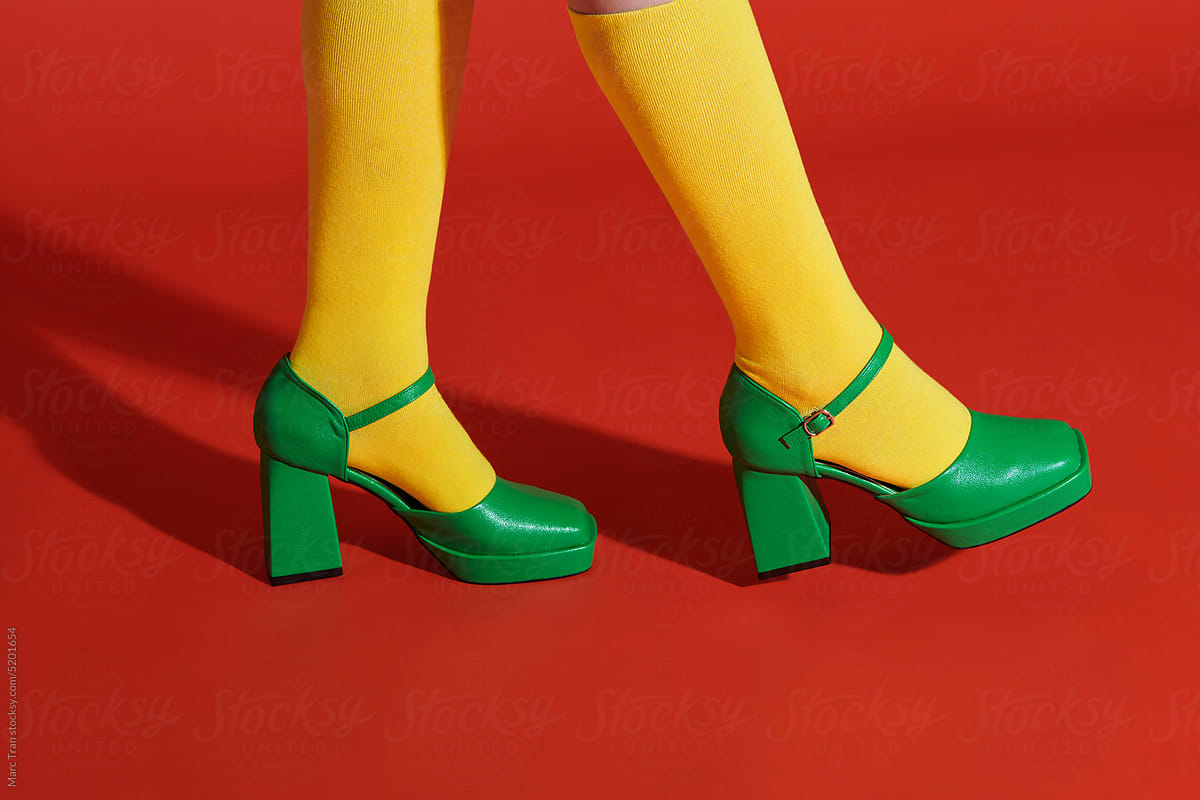 Girls legs isolated on red background with yellow socks