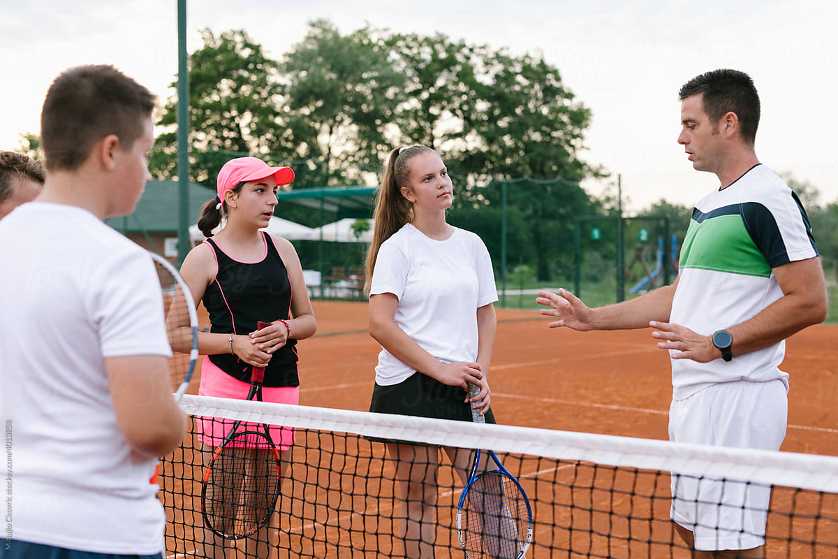 Coach Giving Children Lesson In Tennis