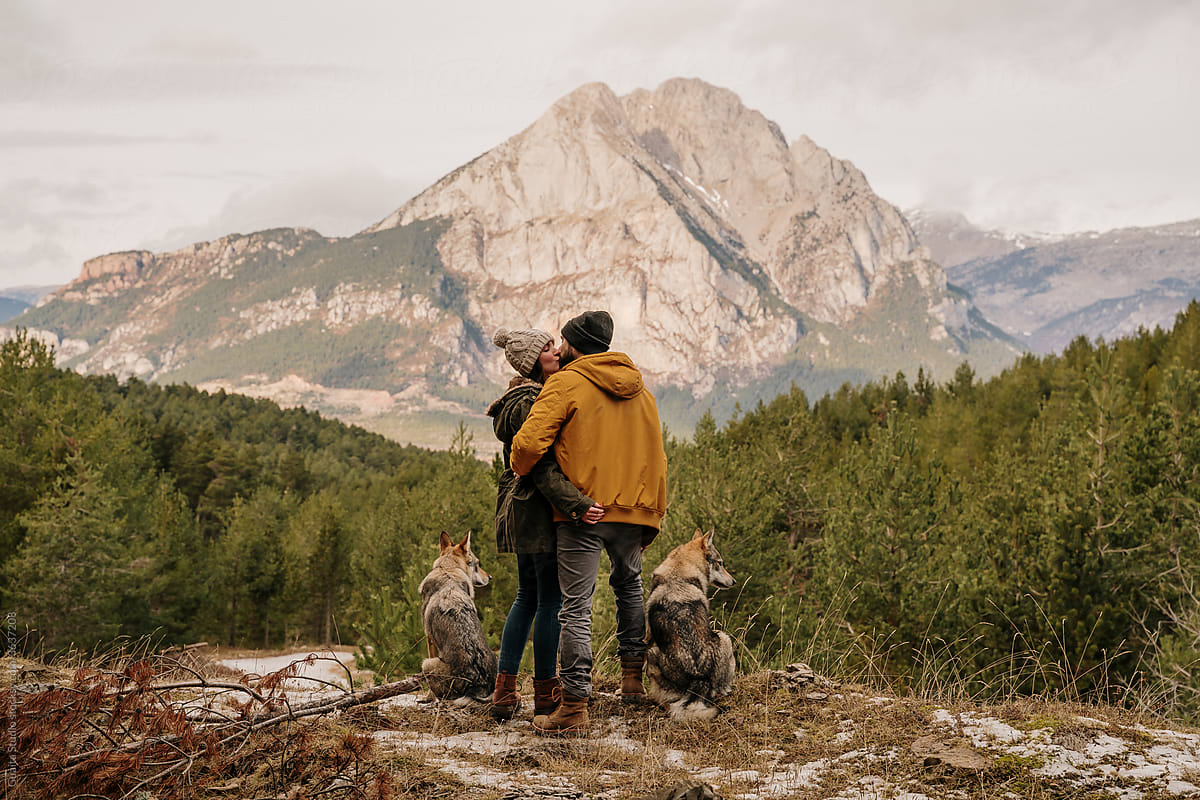 Couple with wolf dogs hiking in the mountain