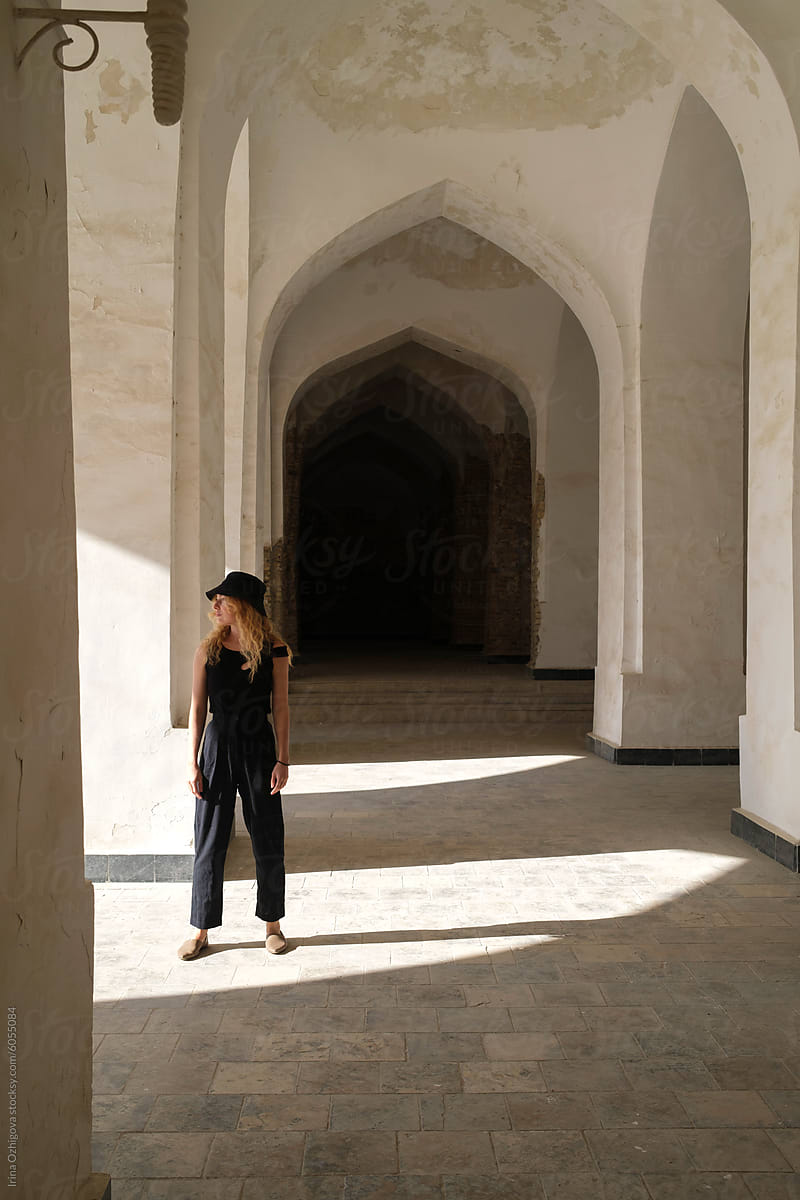 Woman  standing in the arched paths of an ancient courtyard
