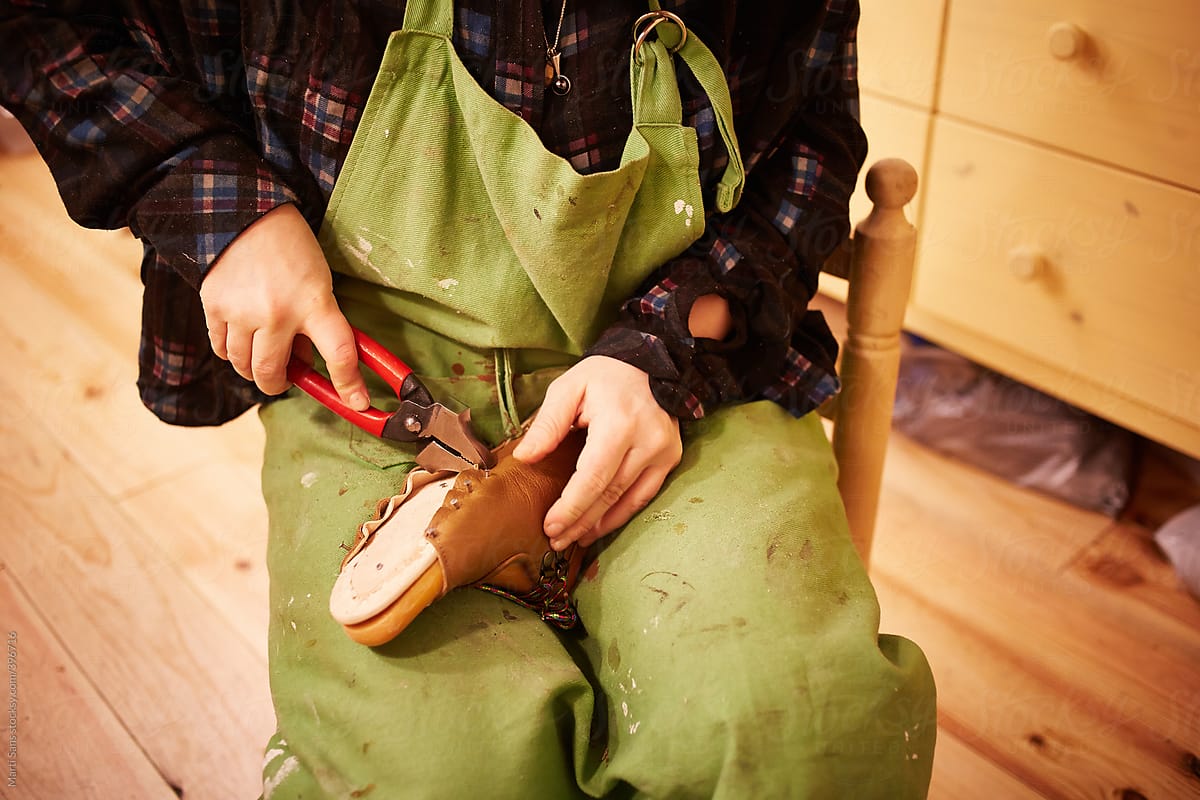 Shoemaker with pliers on leather shoes