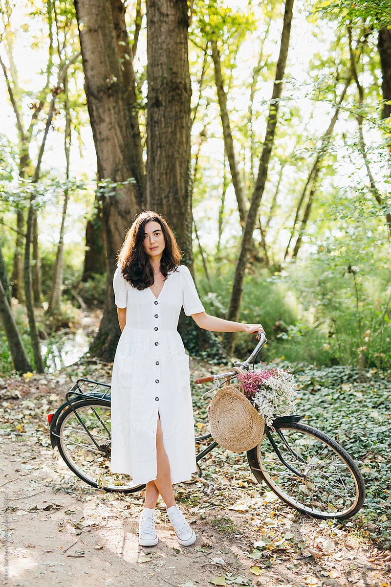 Girl in the wood posing with her bicycle