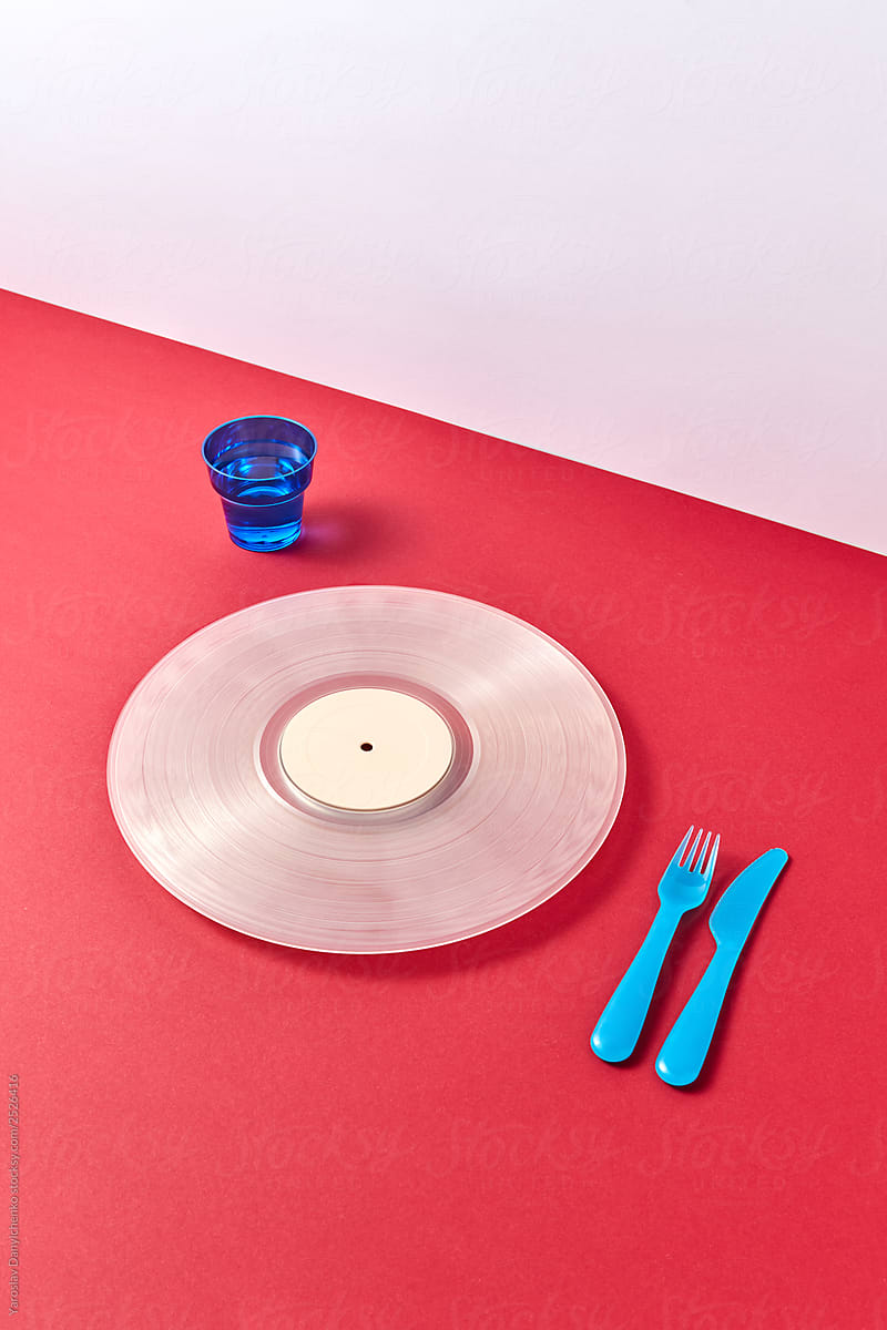 Set of disposable dishes with vinyl record on a duotone background.