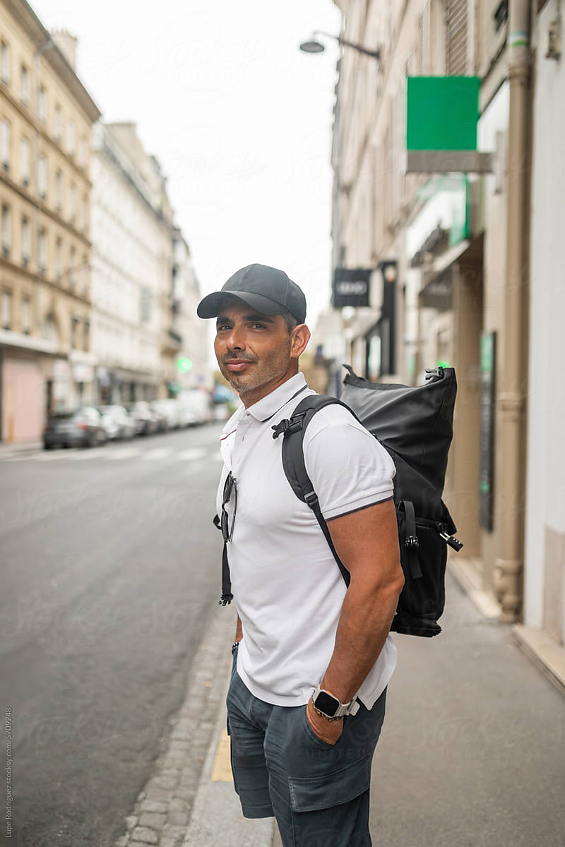 Tourist man walking in Paris with backpack