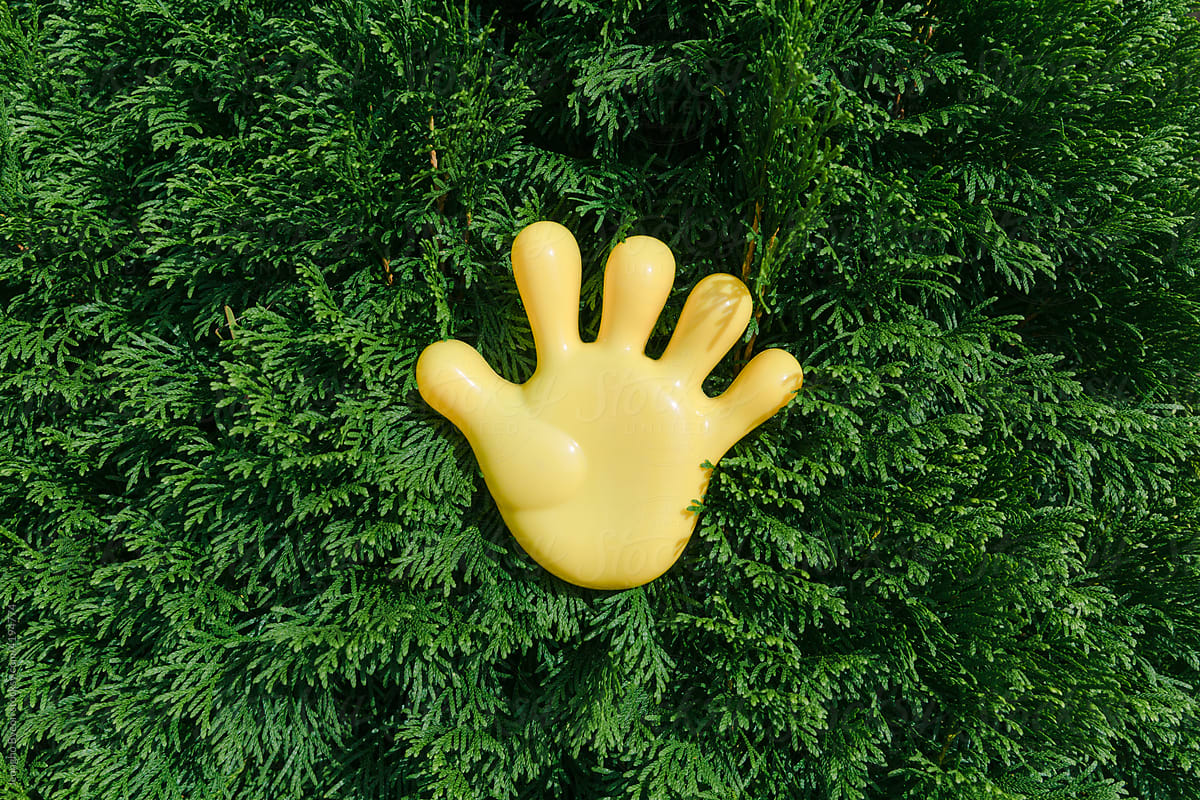A yellow hand-shaped toy and a green tree.