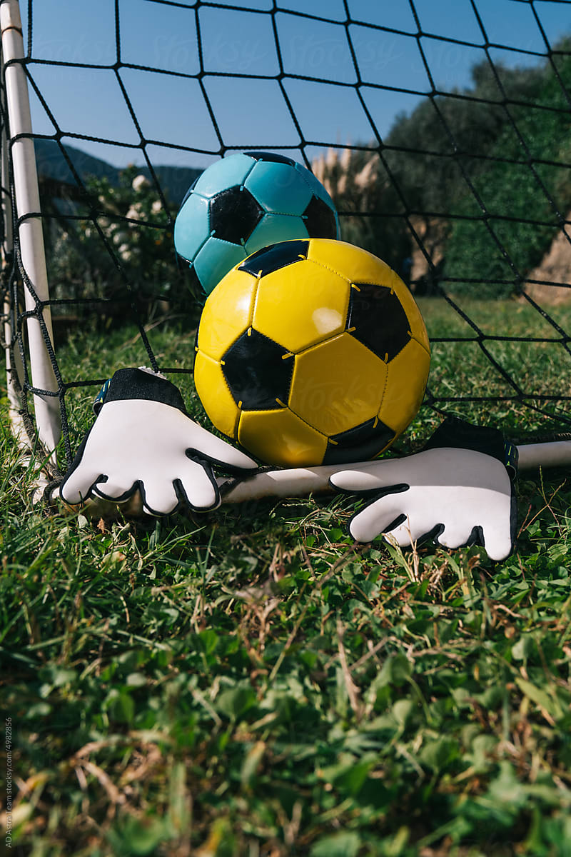 Two soccer balls and goalkeeper\'s gloves