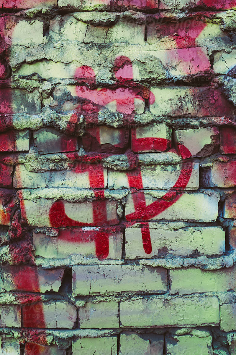 Money symbol spray painted on building wall