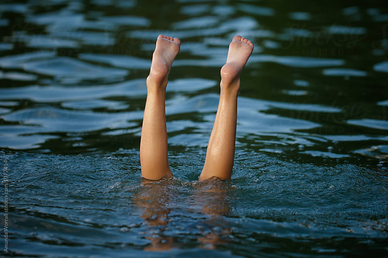 Child doing handstands in the lake