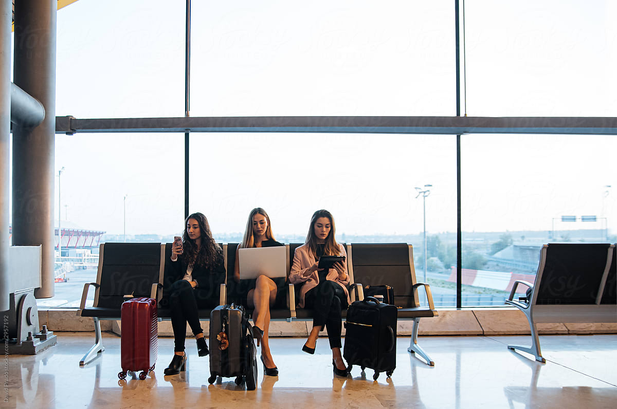 Female entrepreneurs using gadgets in airport