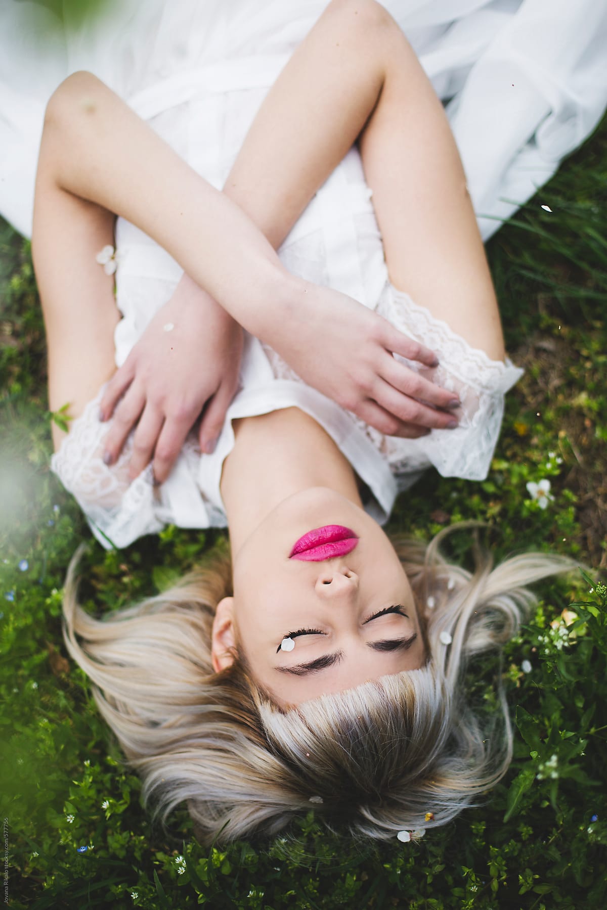 Portrait Of A Young Woman Lying On A Grass By Stocksy Contributor