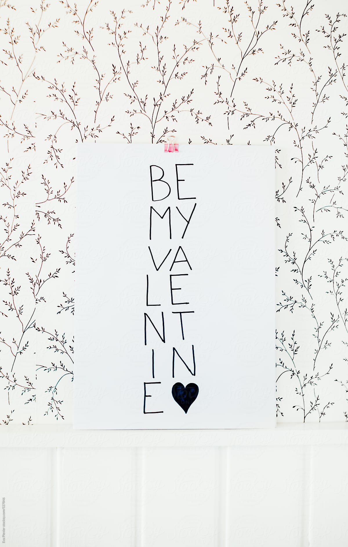 Be my valentine note hanging on the wall.