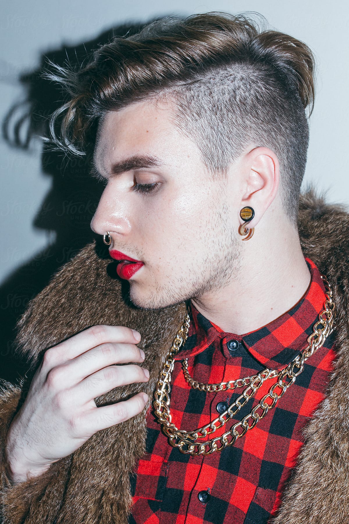 beautiful young man with red lipstick and golden necklace in a Fur Coat , fashion , hairstyle