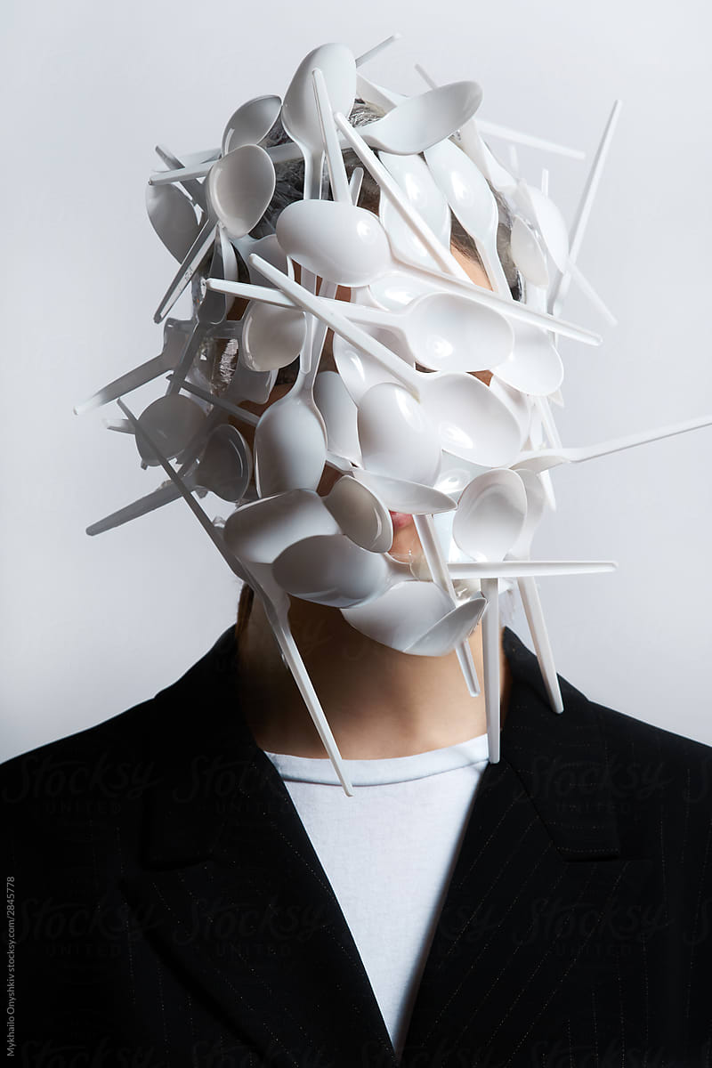 woman face covered with plastic spoons, ecological concept